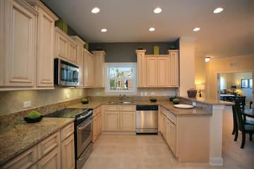 A kitchen with wooden cabinets and granite counter tops.