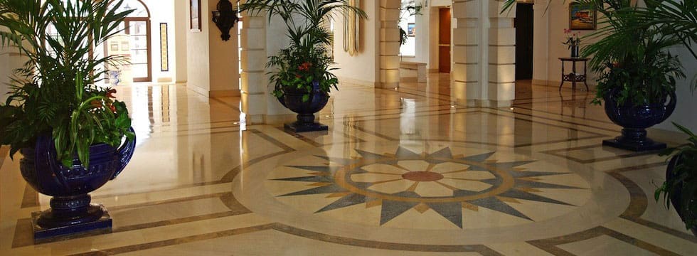 A large room with marble floors and a plant in the center.