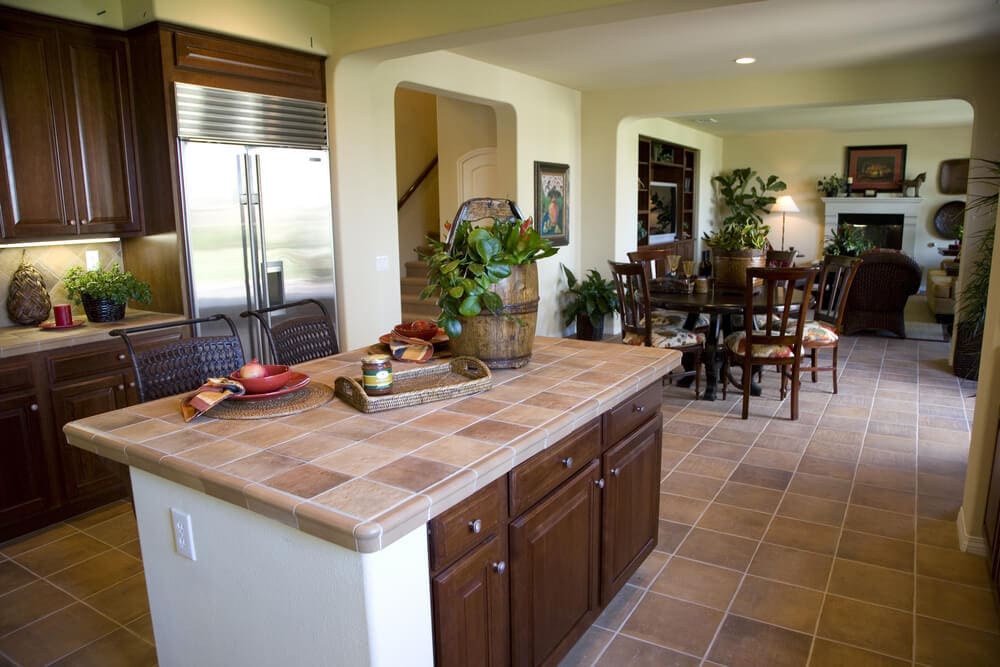 A kitchen with tile floors and brown cabinets.