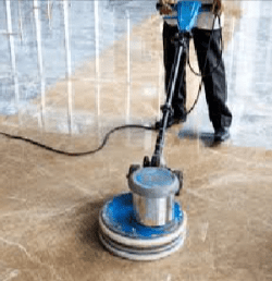 A man is cleaning the floor with a machine.