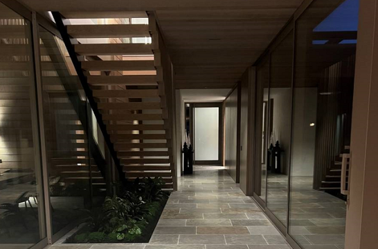 A hallway with stairs and glass doors leading to the second floor.