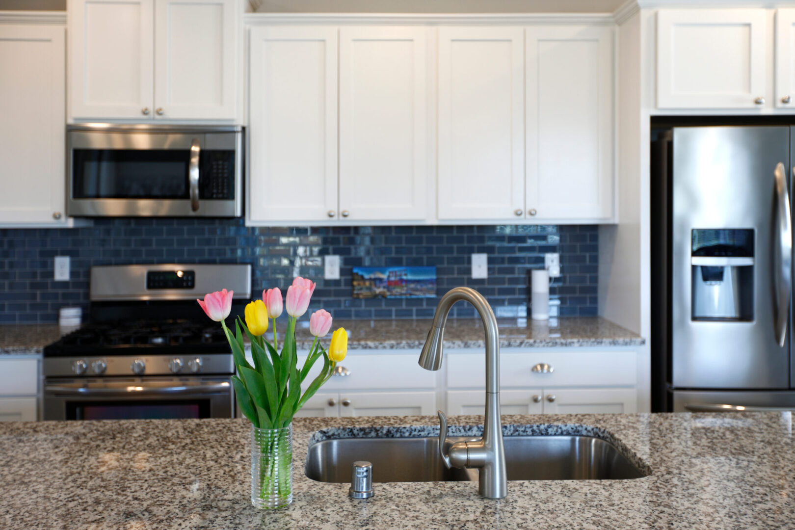 White,And,Grey,Kitchen,Interior,With,Spring,Flowers,And,Granite